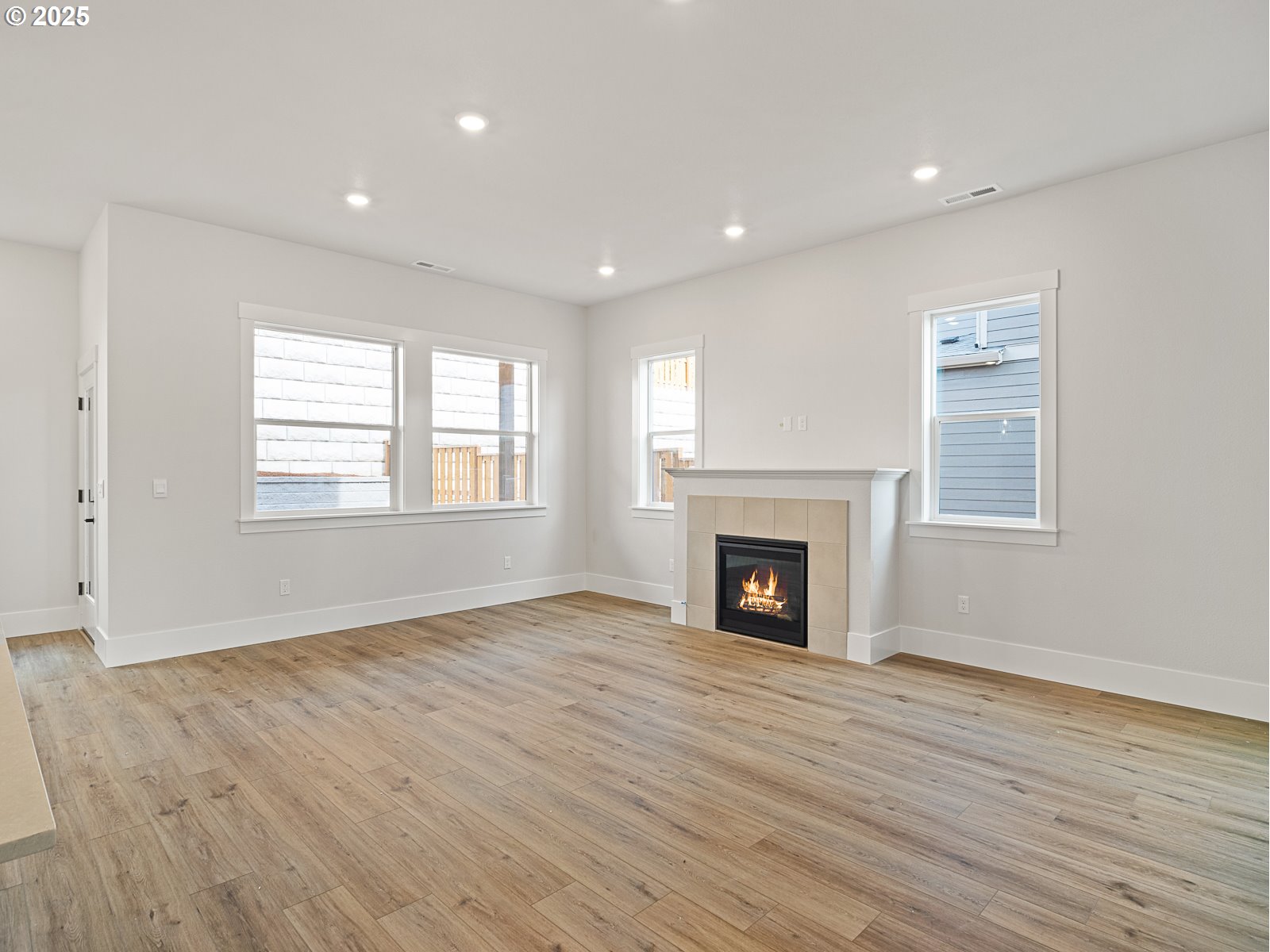 18045 Southwest Monashee Lane Beaverton, OR 97007 - Photo 8 of 45 a view of an empty room with wooden floor fireplace and a window