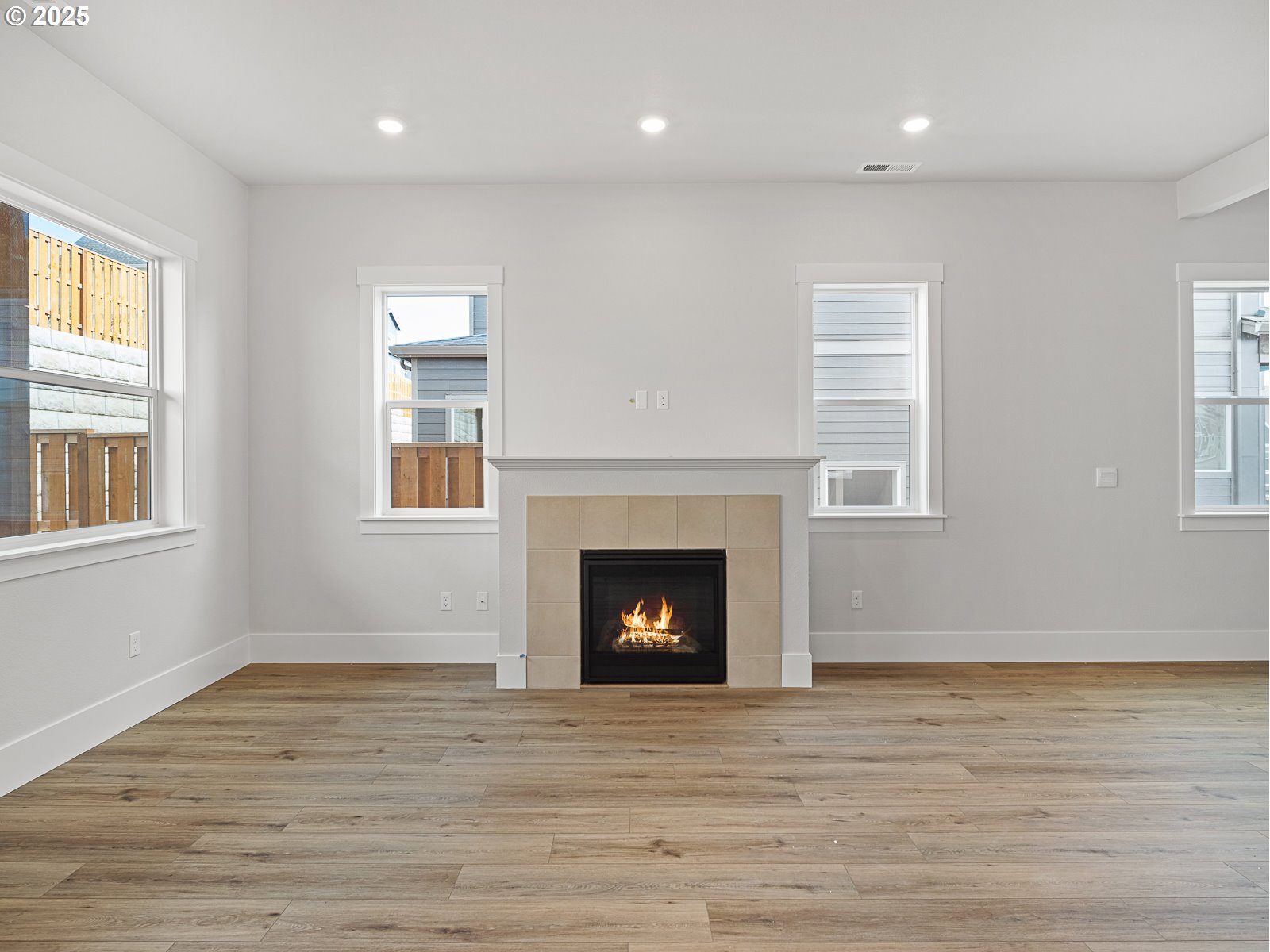 18045 Southwest Monashee Lane Beaverton, OR 97007 - Photo 9 of 45 a view of an empty room with wooden floor fireplace and a window