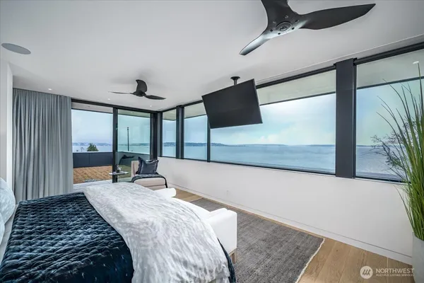 a bedroom with a large bed couch and a large window