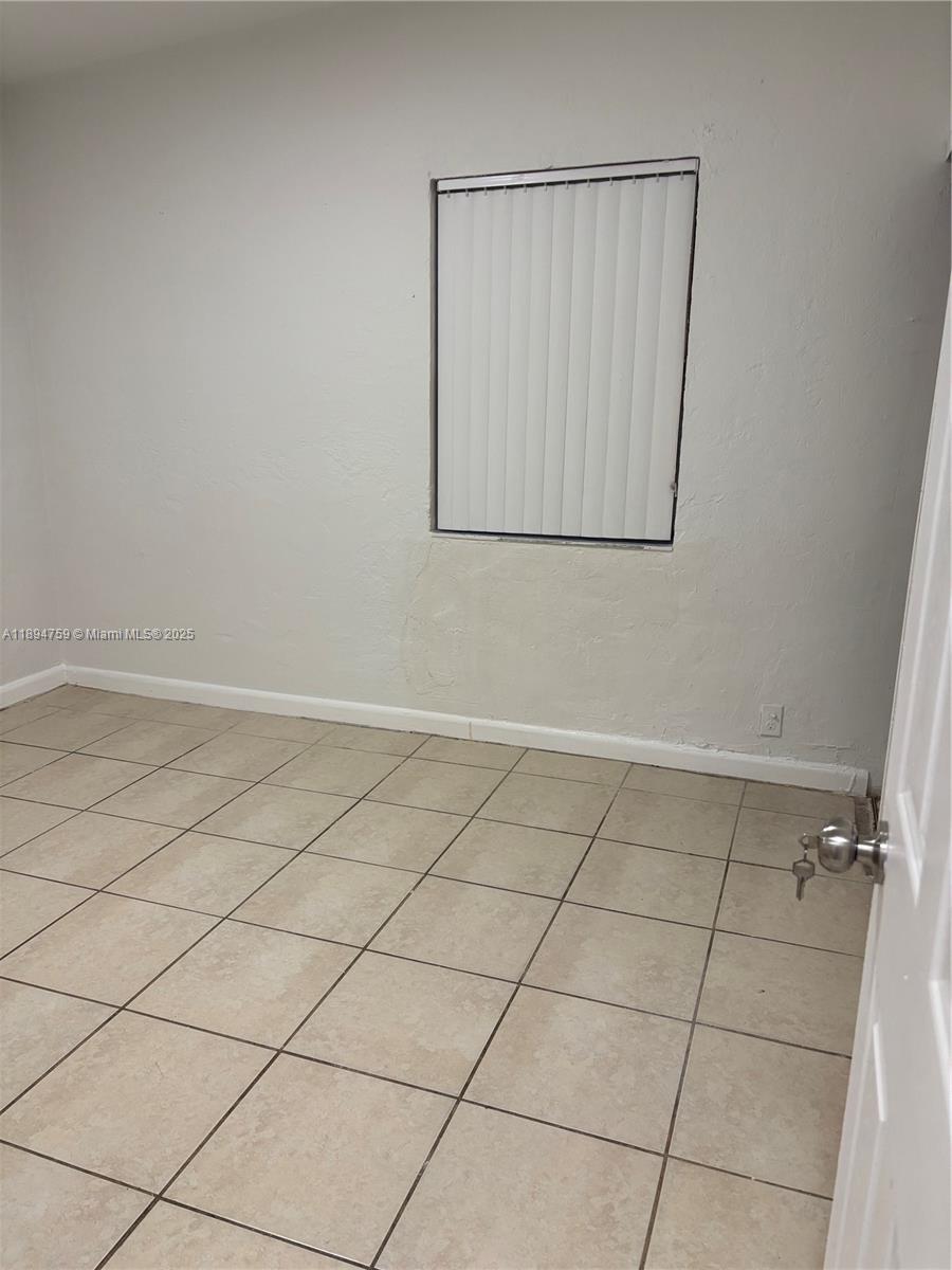 2070 Washington Avenue, Unit 2 Opa-Locka, FL 33054 - Photo 4 of 6 an empty room with a bench