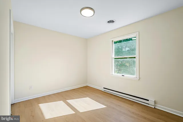 a view of a room with wooden floor and a window