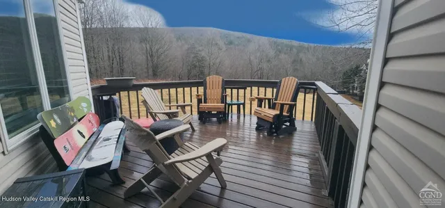 a balcony with wooden floor and outdoor seating
