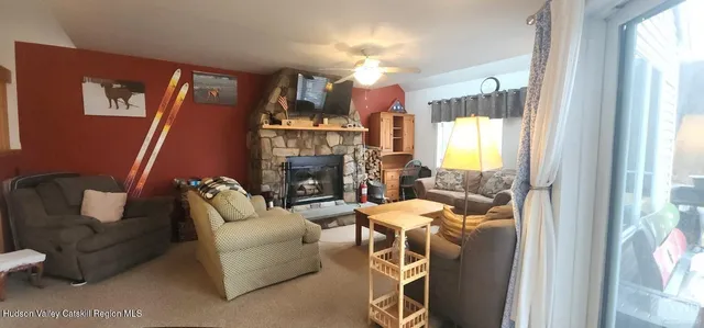 a living room with furniture a fireplace and a large window