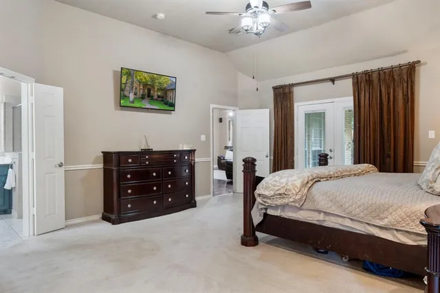 a spacious bedroom with a bed and ceiling fan