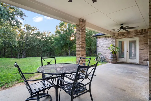 a view of a house next to a big yard and large trees