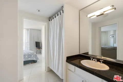 a en suite bathroom with a granite countertop sink and a mirror