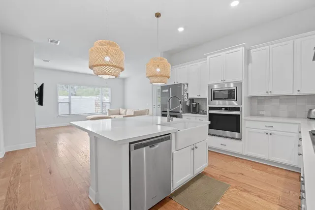 a kitchen with kitchen island granite countertop a sink a stove and cabinets