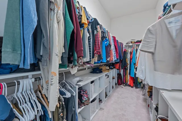 a view of walk in closet with clothes