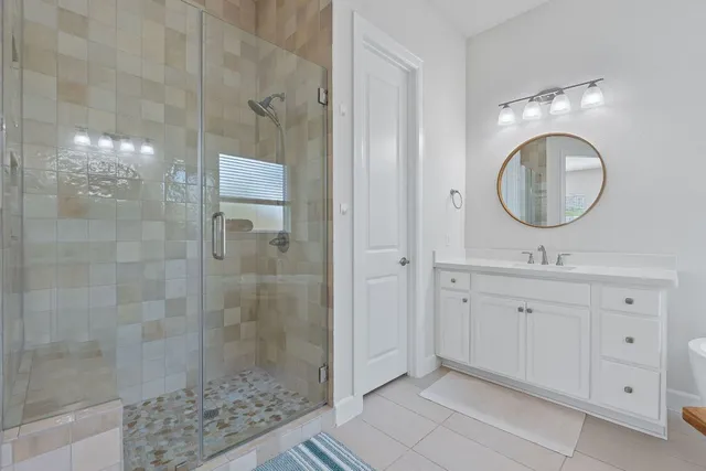 a bathroom with a double vanity sink mirror and shower