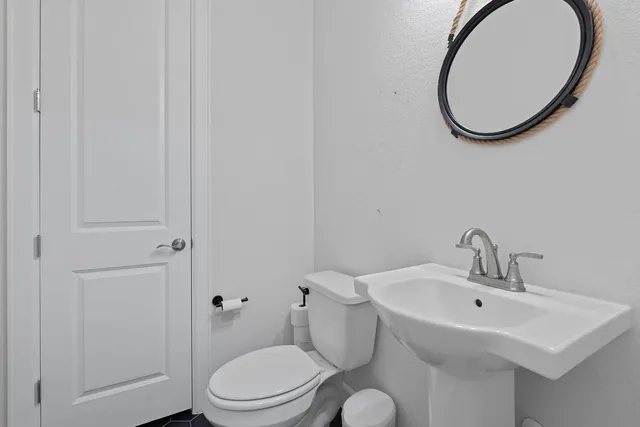a bathroom with a toilet a sink and a mirror