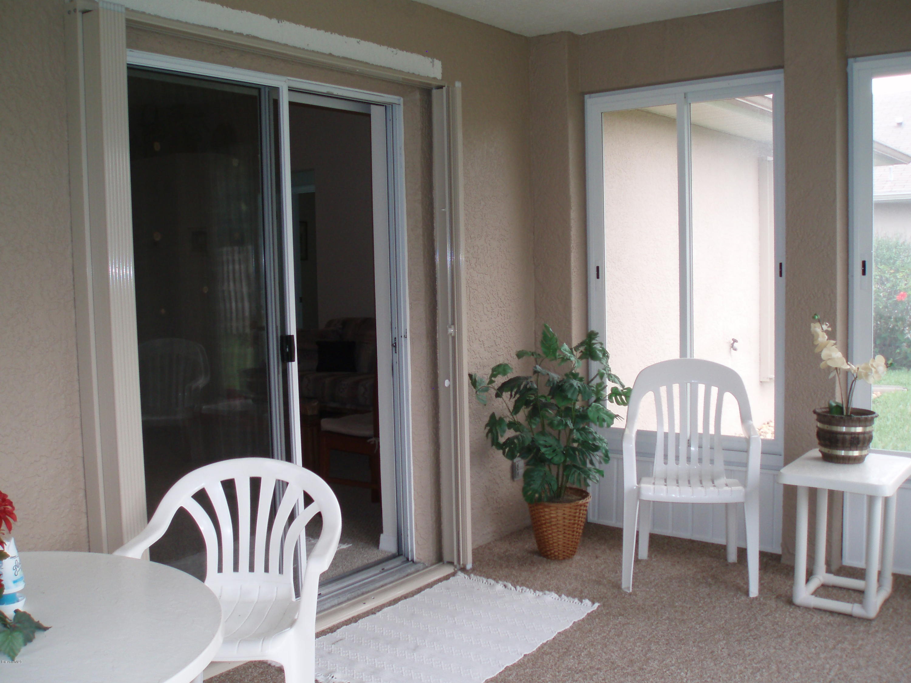 267 Twin Lakes Road Melbourne, FL 32901 - Photo 15 of 33 a view of porch with a bench and a floor to ceiling window