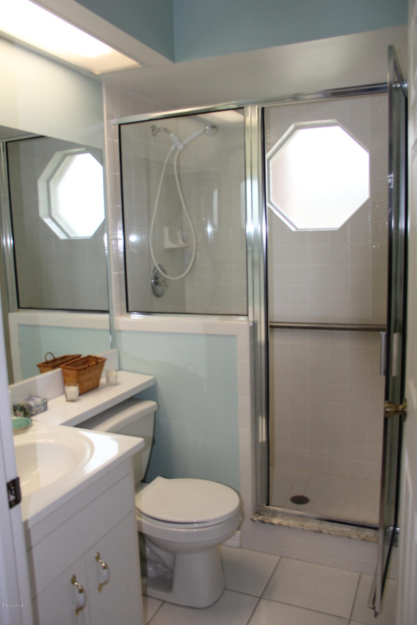 267 Twin Lakes Road Melbourne, FL 32901 - Photo 19 of 33 a bathroom with a toilet a sink and a mirror
