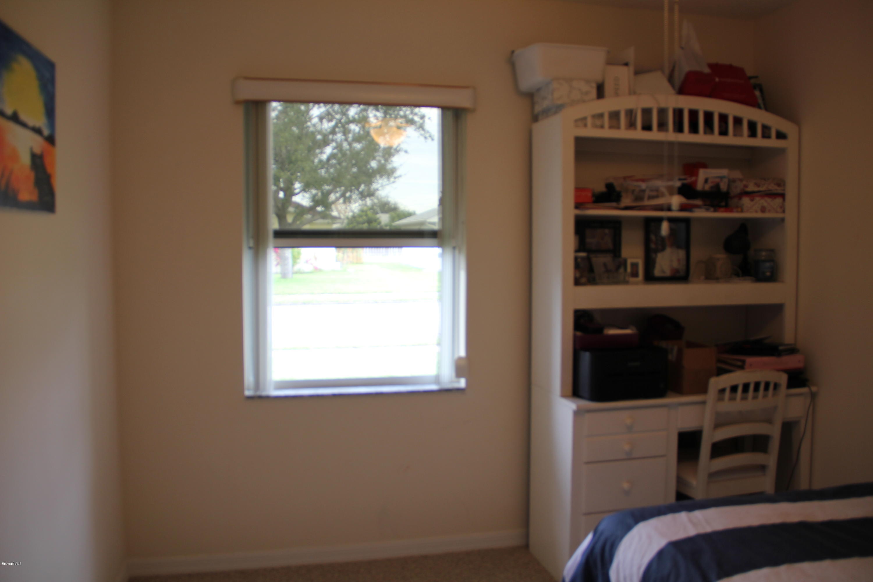 267 Twin Lakes Road Melbourne, FL 32901 - Photo 20 of 33 a view of a bedroom with cabinets and a window