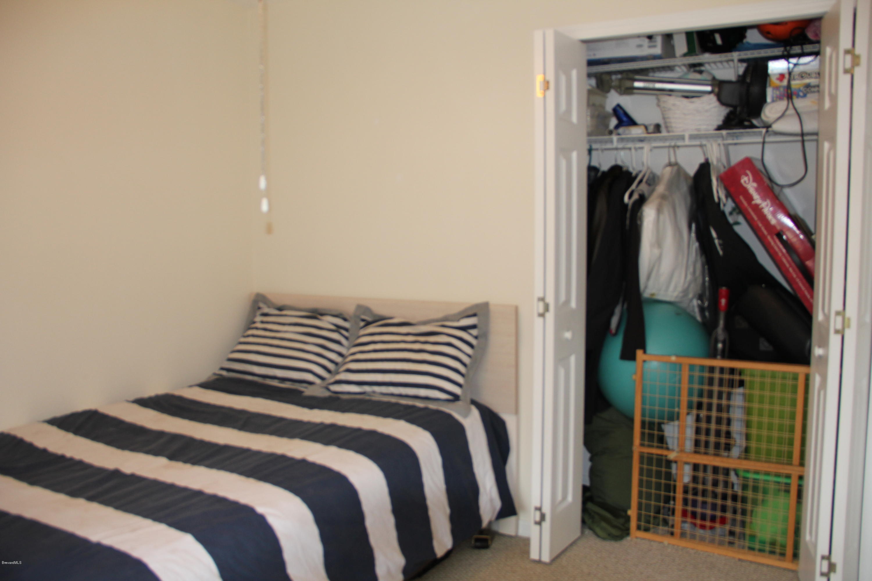267 Twin Lakes Road Melbourne, FL 32901 - Photo 21 of 33 a bedroom with a bed and a walk in closet