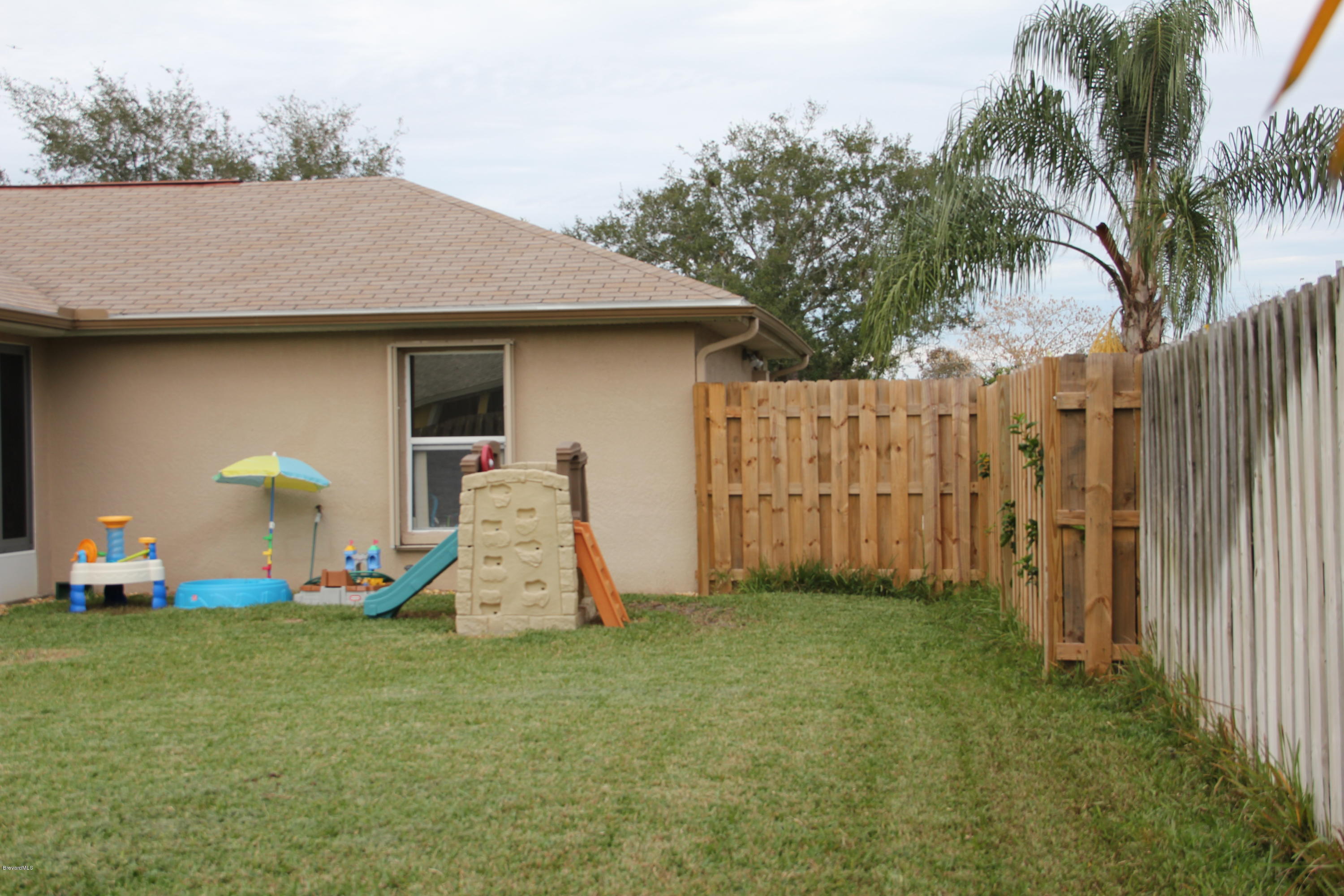 267 Twin Lakes Road Melbourne, FL 32901 - Photo 25 of 33 a front view of a house with a yard and garage