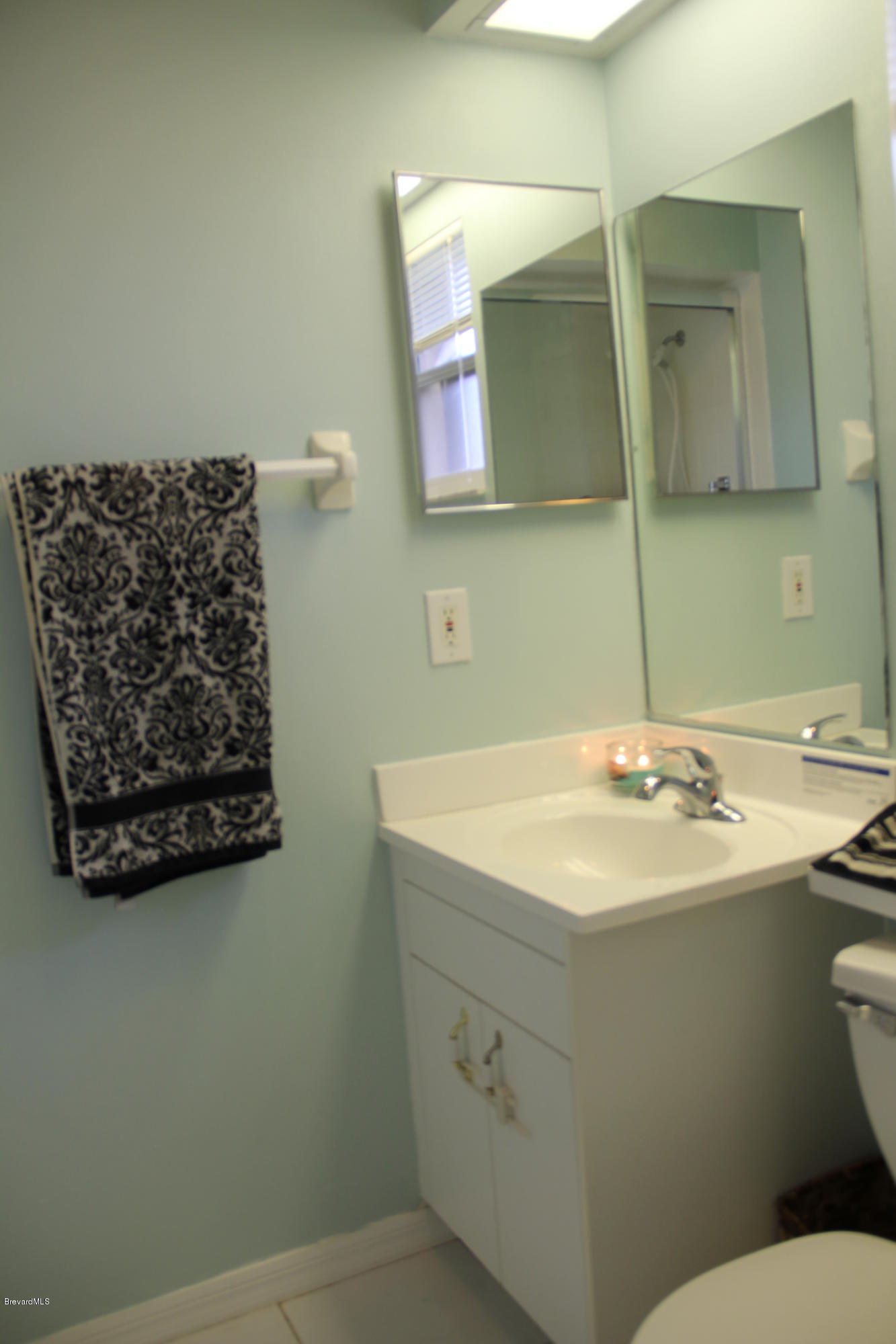 267 Twin Lakes Road Melbourne, FL 32901 - Photo 5 of 33 a bathroom with a toilet sink and mirror