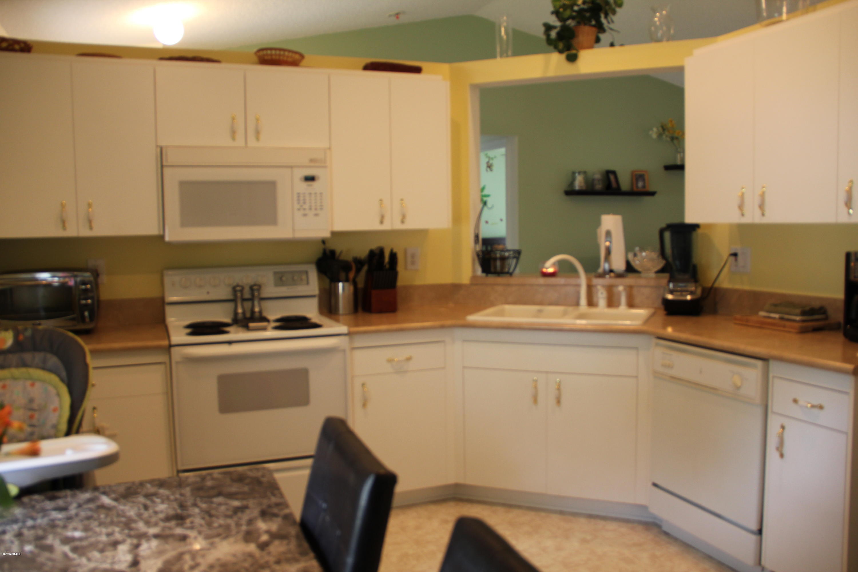267 Twin Lakes Road Melbourne, FL 32901 - Photo 8 of 33 a kitchen with a sink cabinets and appliances