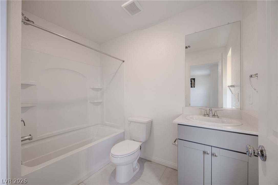 5927 Coja Street Las Vegas, NV 89113 - Photo 30 of 32 Bathroom featuring vanity, toilet, tile patterned floors, shower / washtub combination, and baseboards
