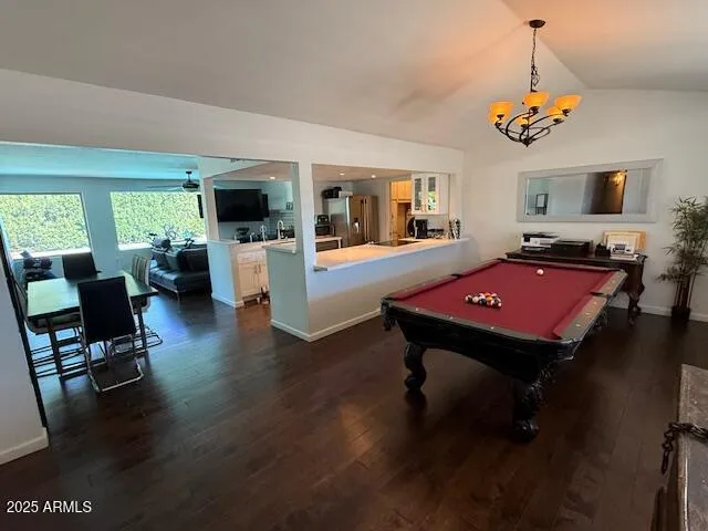 a room with wooden floor pool table and windows