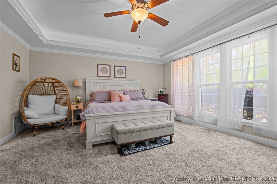 758 Micahs Way North Spring Lake, NC 28390 - Photo 32 of 36 a spacious bedroom with a bed a couch and a chandelier