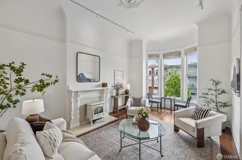 a living room with furniture fireplace and potted plant