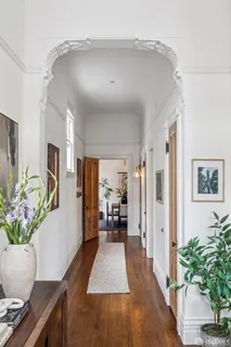 a view of a hallway with wooden floor and furniture