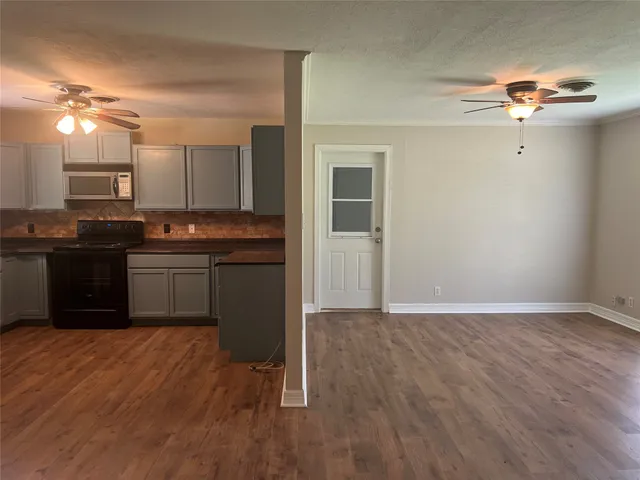 a kitchen with kitchen island granite countertop a sink cabinets and wooden floor