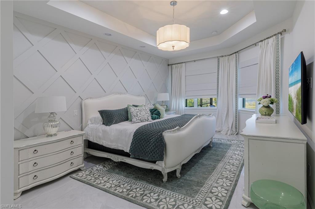 8963 Gustavia Court Naples, FL 34113 - Photo 11 of 47 a bed room with a bed window and mirror