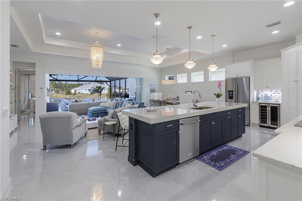 8963 Gustavia Court Naples, FL 34113 - Photo 4 of 47 a large kitchen with a counter space dining table and a chandelier
