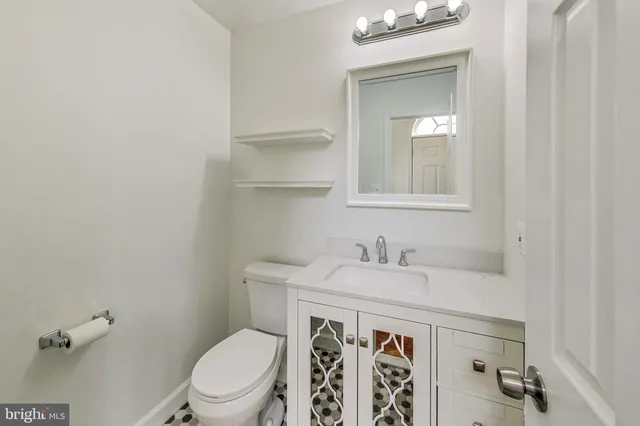 a bathroom with a sink a toilet and a mirror