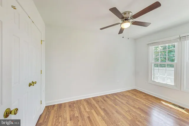 an empty room with a window and wooden floor