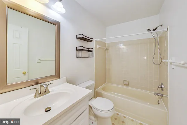 a bathroom with a bathtub shower sink vanity mirror and toilet