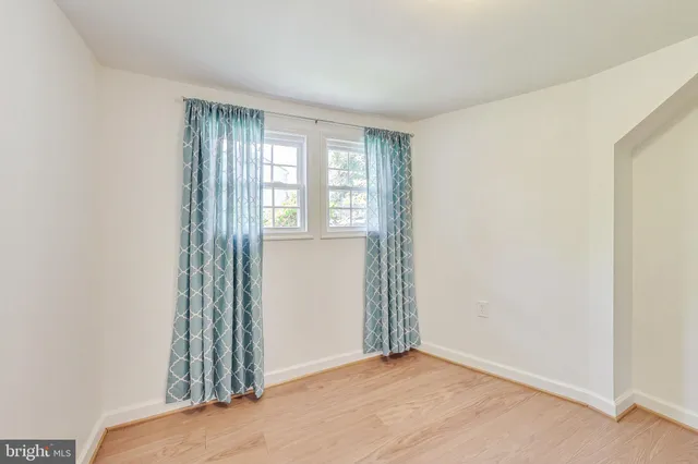 a view of a room with wooden floor and windows