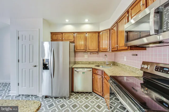 a kitchen with stainless steel appliances granite countertop a refrigerator and a stove