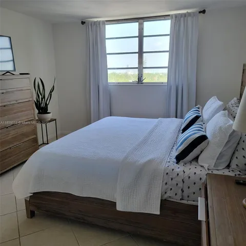 a front view of a building with a garden and trees