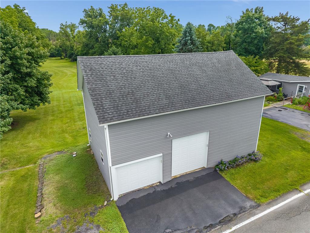 4831 Steuben Road Nazareth, PA 18064 - Photo 28 of 34 Two garage doors open to ample storage or workspace, complemented by vast grassy surroundings.