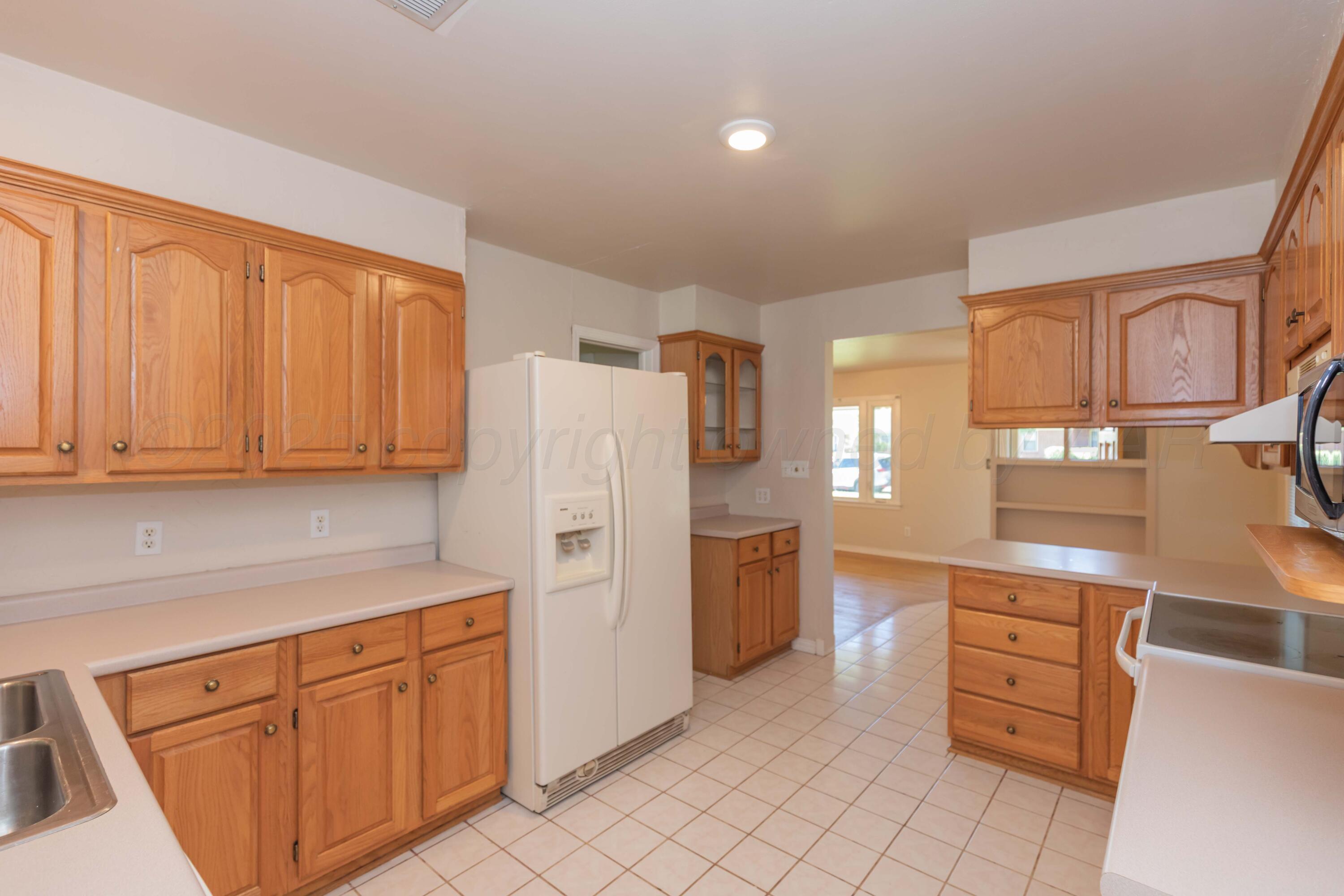 3513 Concord Road Amarillo, TX 79109 - Photo 11 of 45 a kitchen with cabinets and a refrigerator