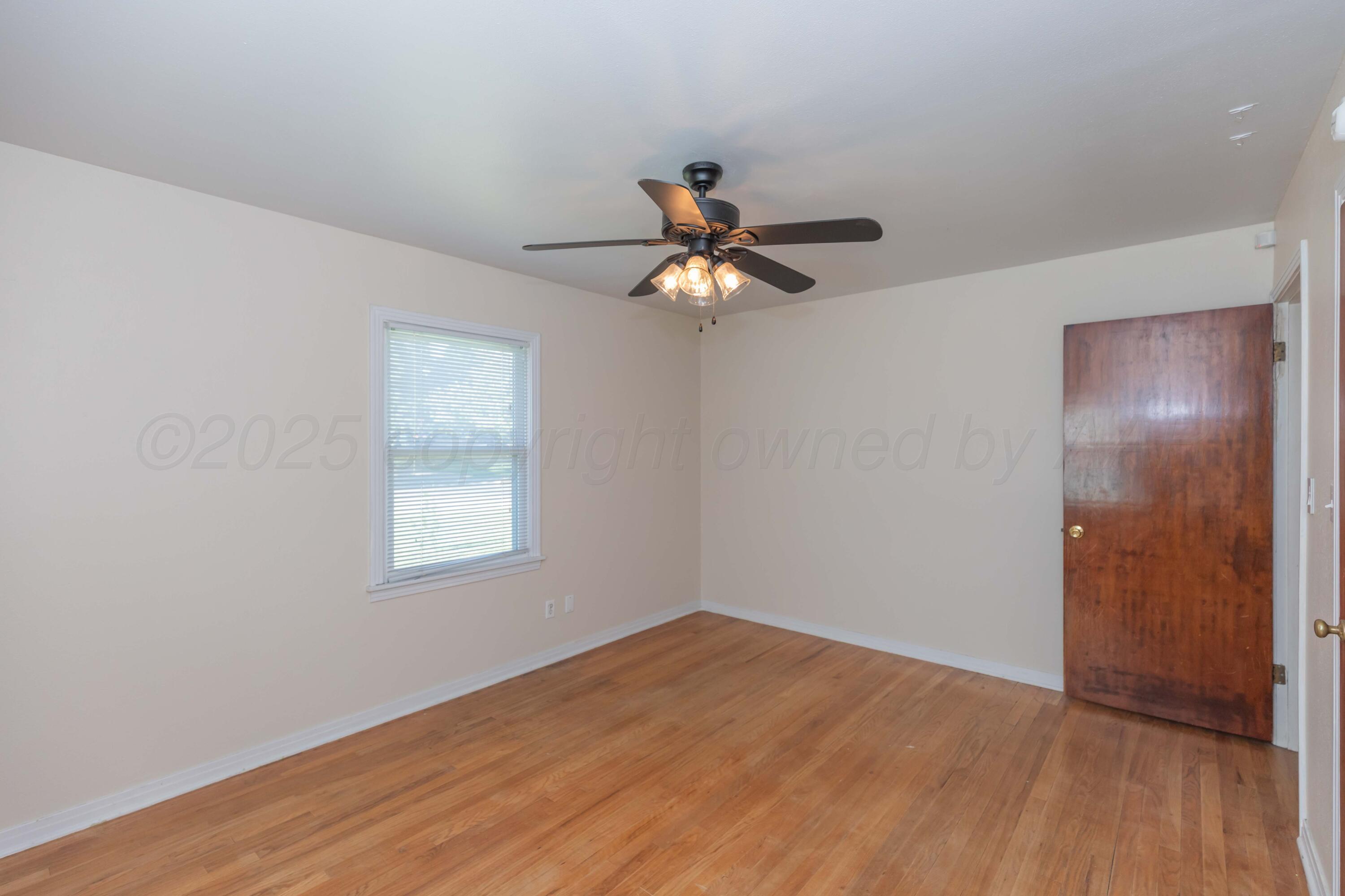 3513 Concord Road Amarillo, TX 79109 - Photo 20 of 45 a view of a room with wooden floor and a ceiling fan