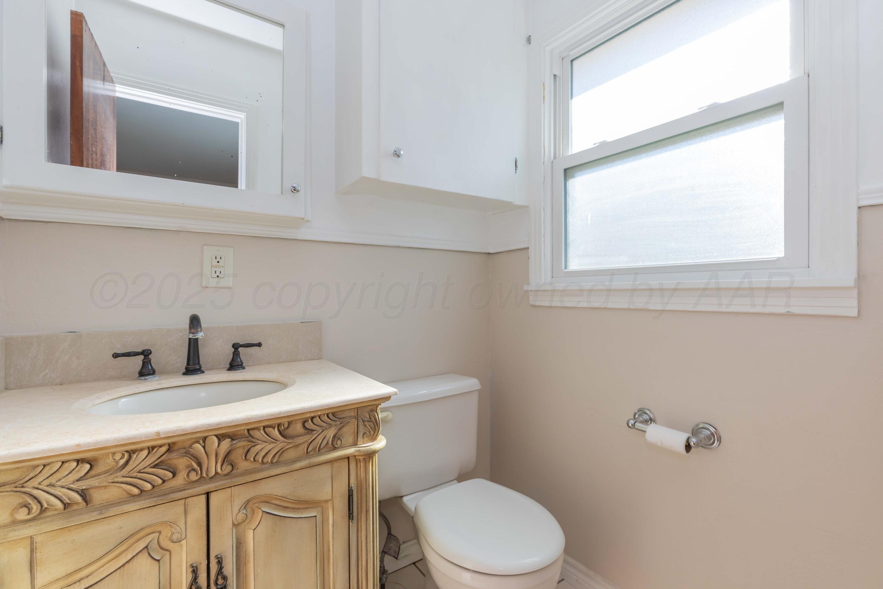 3513 Concord Road Amarillo, TX 79109 - Photo 21 of 45 a bathroom with a sink a toilet and mirror