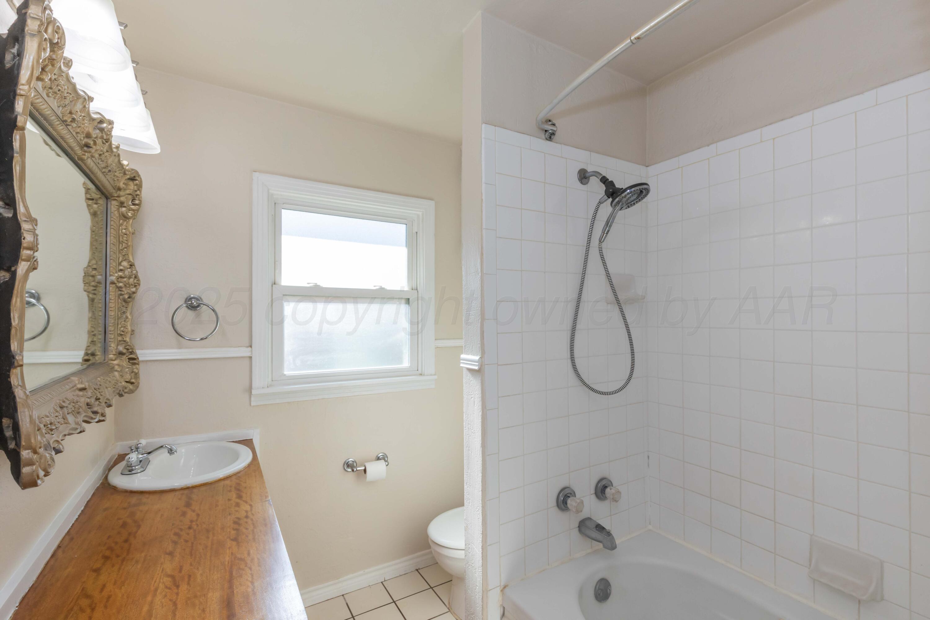 3513 Concord Road Amarillo, TX 79109 - Photo 29 of 45 a bathroom with a granite countertop sink a toilet and a shower