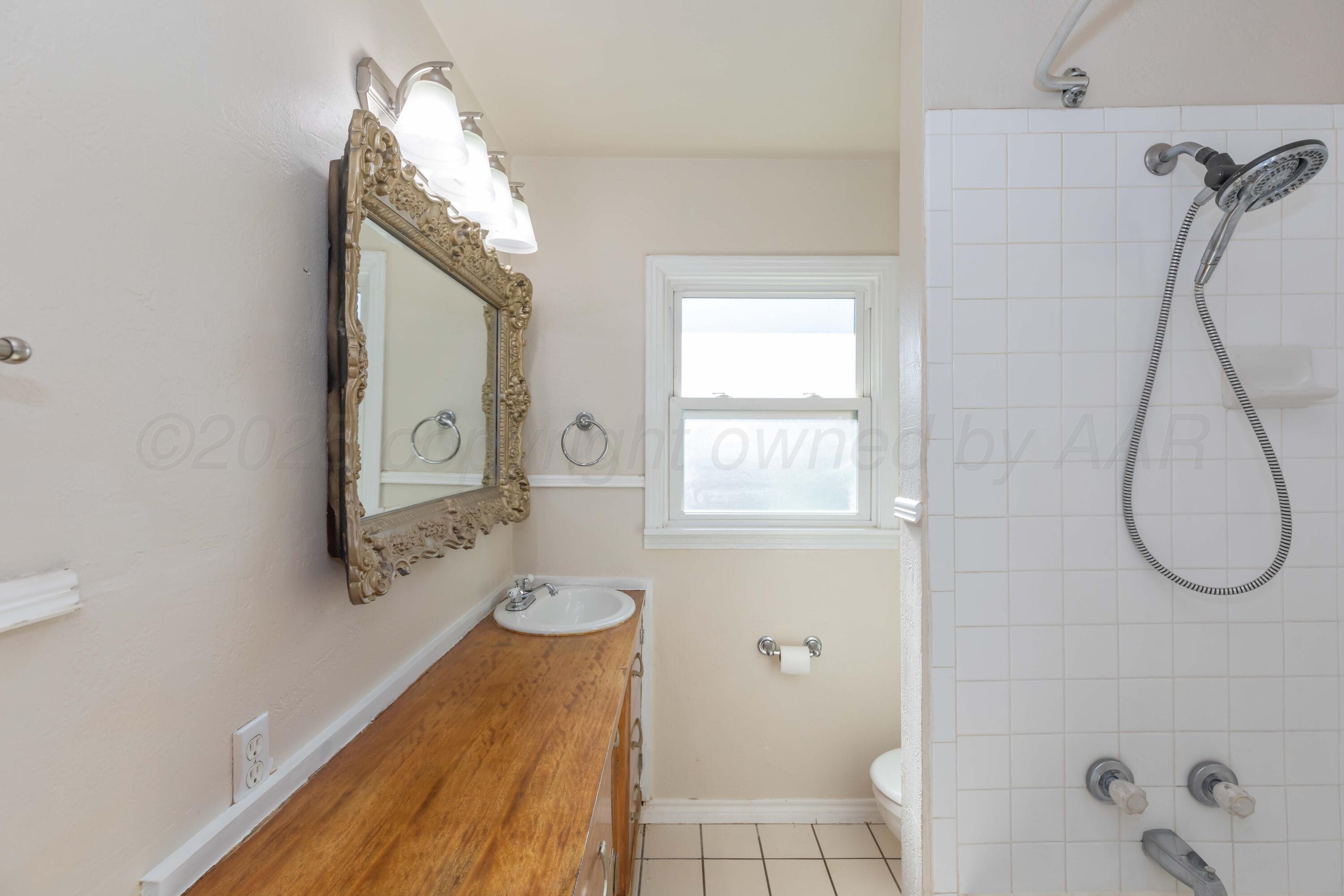 3513 Concord Road Amarillo, TX 79109 - Photo 31 of 45 a bathroom with a tub sink and mirror
