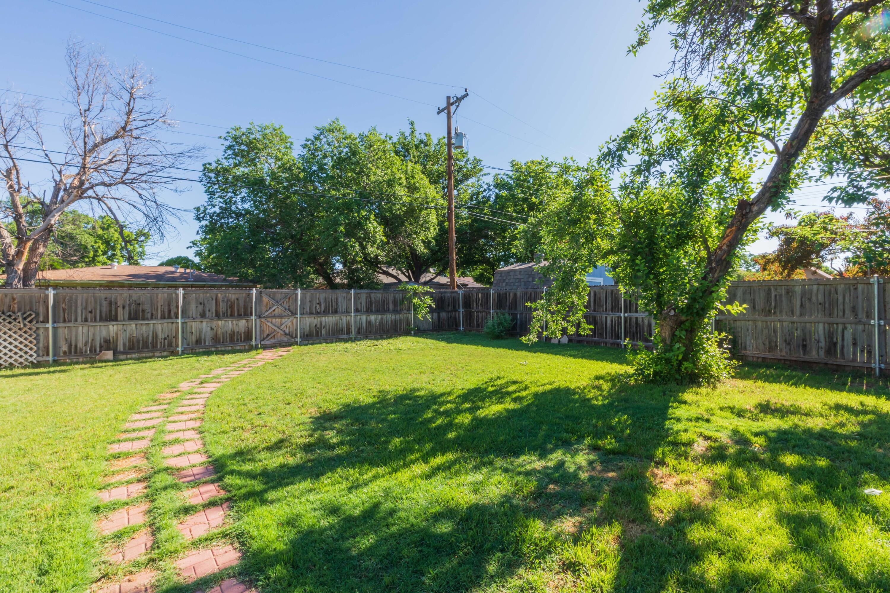 3513 Concord Road Amarillo, TX 79109 - Photo 43 of 45 a view of a backyard with large tree and wooden fence