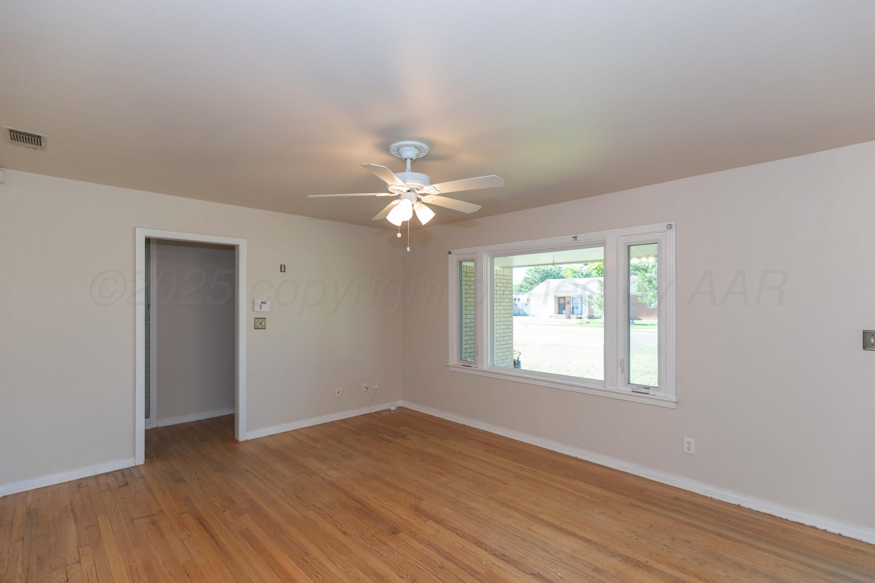 3513 Concord Road Amarillo, TX 79109 - Photo 6 of 45 a view of an empty room with wooden floor and a window