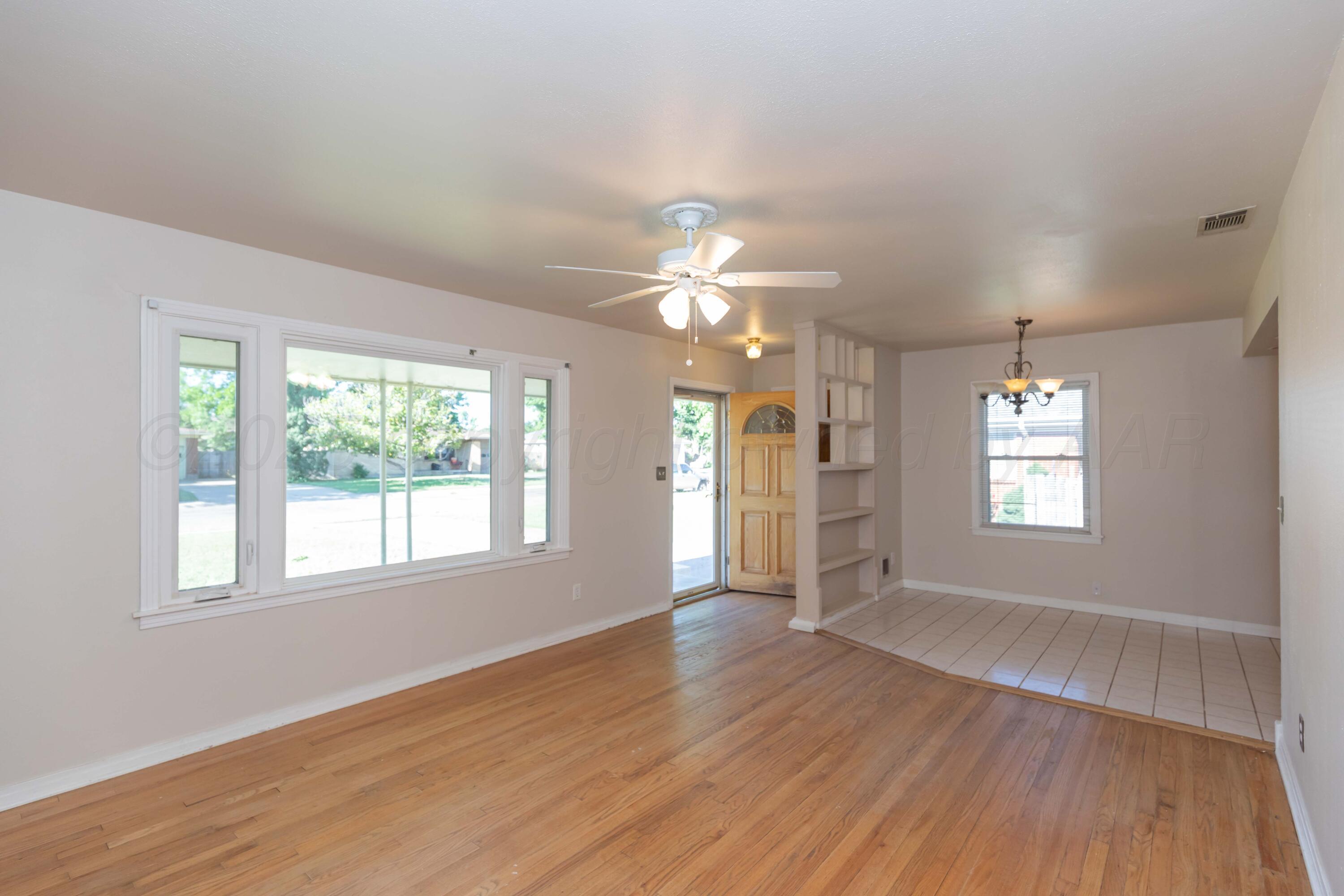 3513 Concord Road Amarillo, TX 79109 - Photo 7 of 45 an empty room with wooden floor and windows