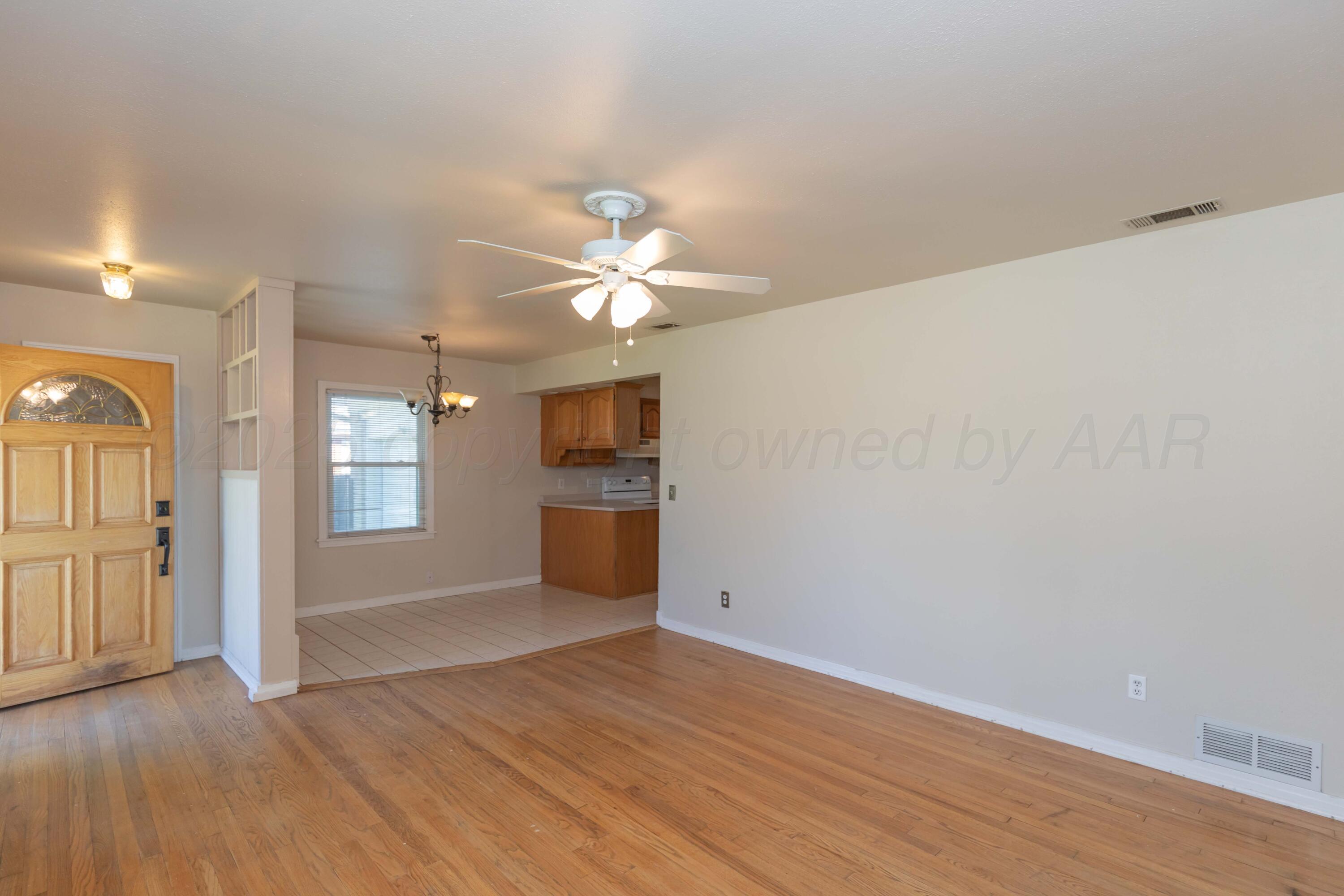 3513 Concord Road Amarillo, TX 79109 - Photo 8 of 45 an empty room with wooden floor and windows