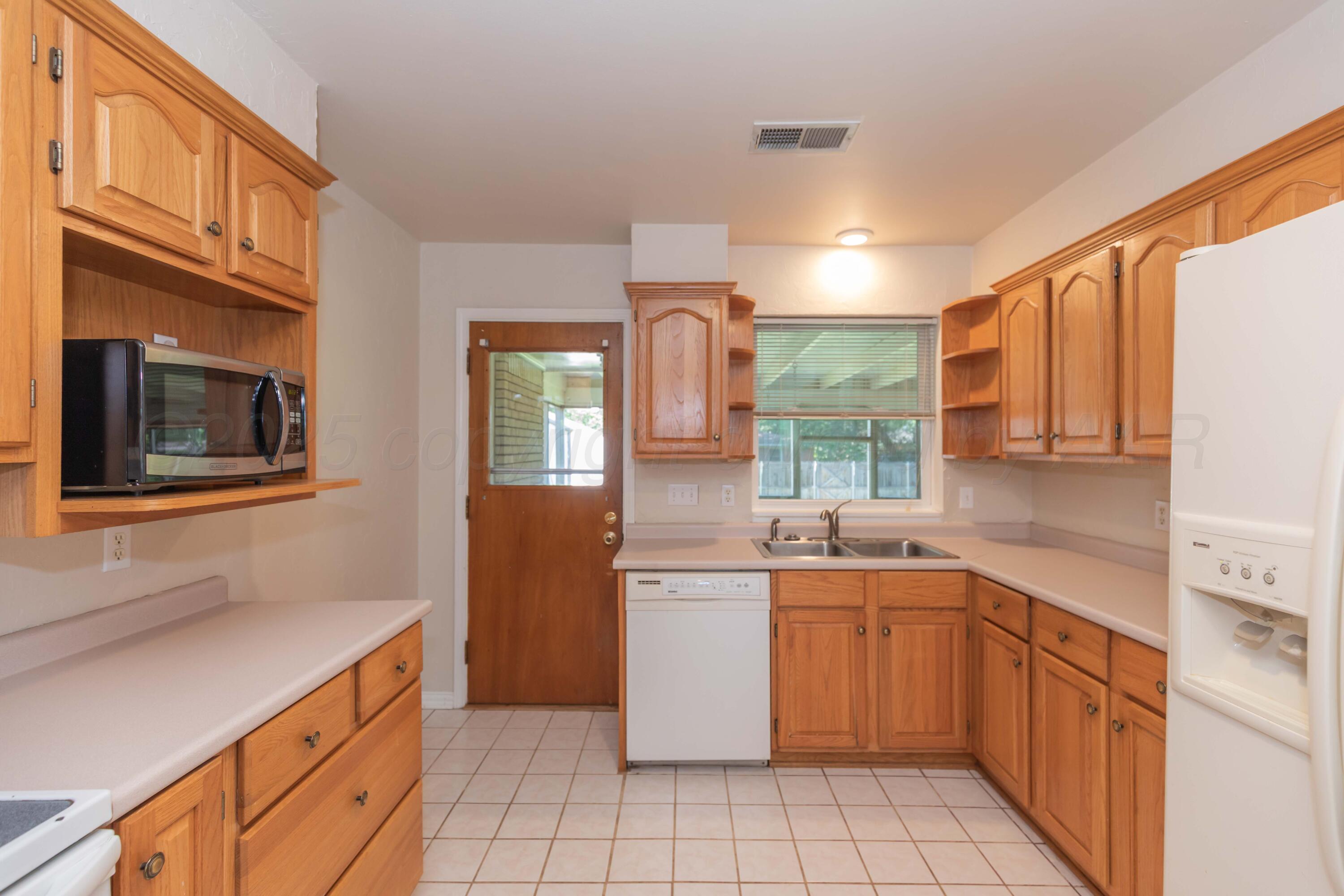 3513 Concord Road Amarillo, TX 79109 - Photo 10 of 45 a kitchen with a sink stove and cabinets