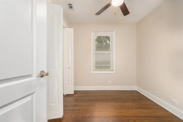 an empty room with a hardwood and ceiling fan