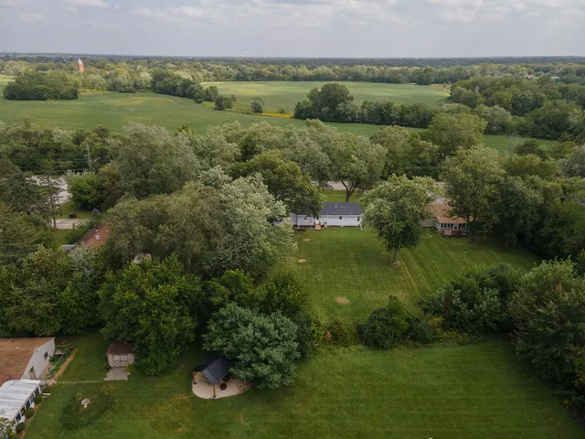 a view of a lush green forest with a house