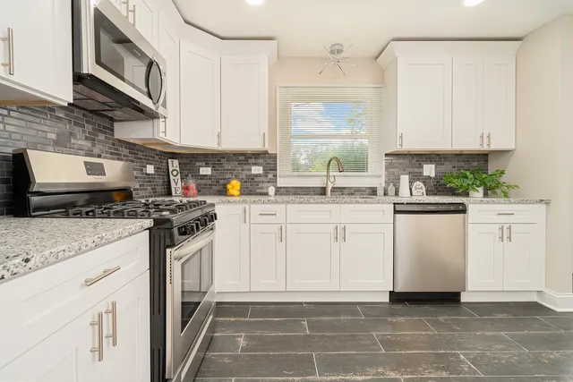 a kitchen with white cabinets and white appliances