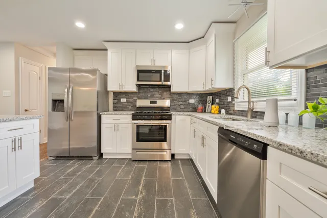 a kitchen with white cabinets stainless steel appliances and a sink